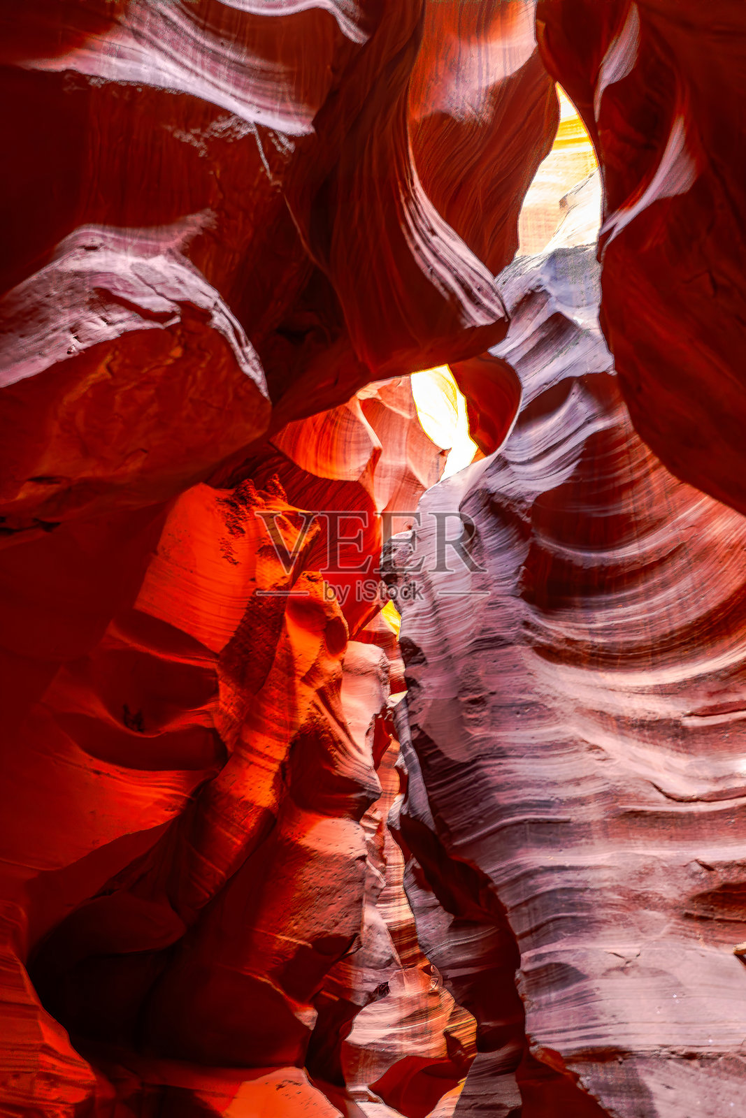 美国一个迷人的狭缝峡谷，展示了在阳光透过狭窄缝隙照射下的鲜艳红色和橙色砂岩形成，突显出复杂的纹理。照片摄影图片
