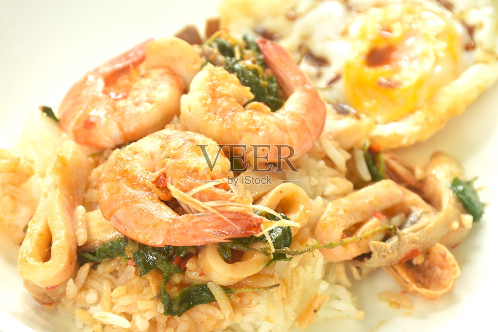 辣味炒虾和鱿鱼，罗勒叶点缀，配蛋，情侣与米饭同享照片摄影图片