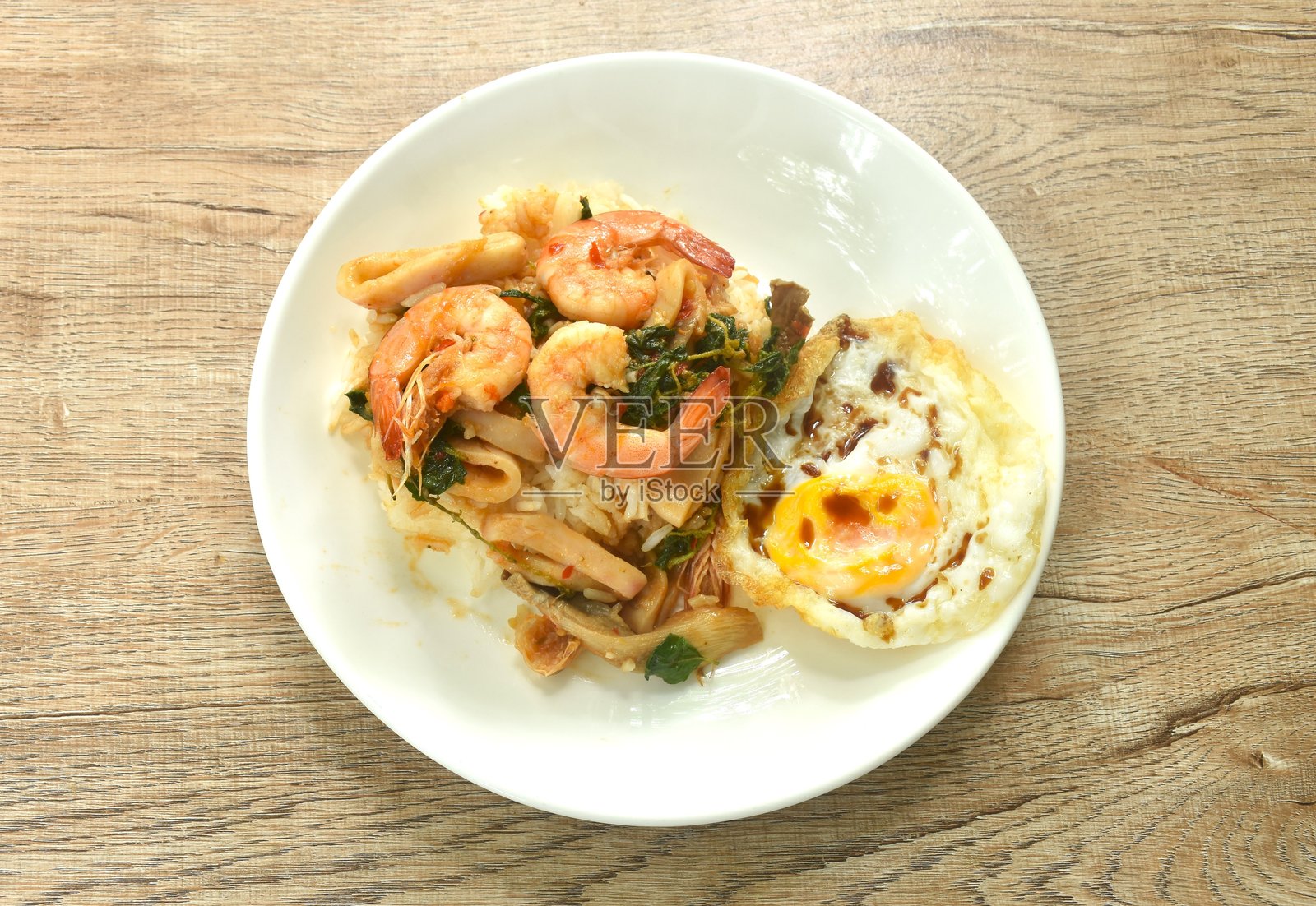 香辣炒虾和鱿鱼，罗勒叶点缀，搭配鸡蛋和米饭的情侣餐照片摄影图片