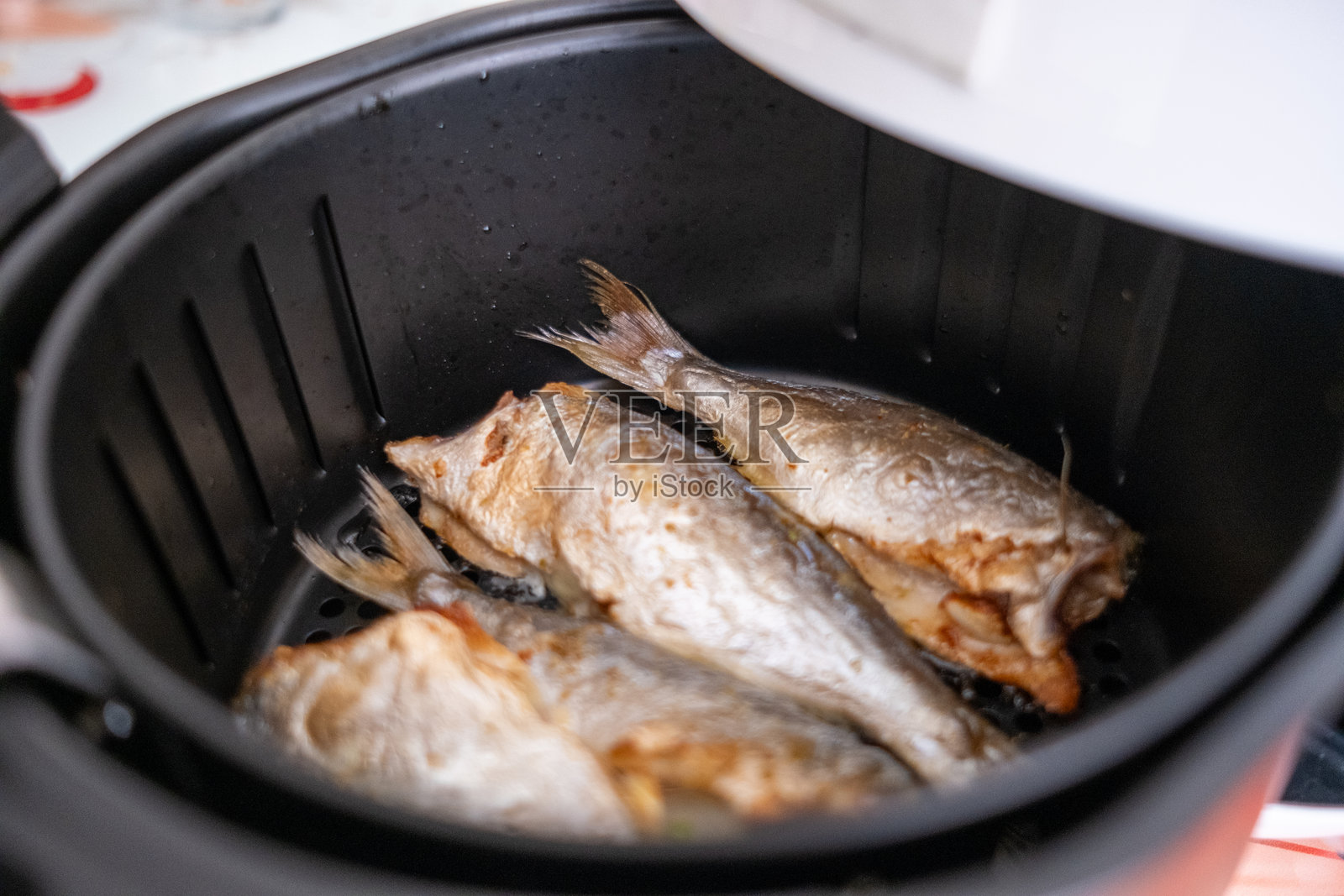 在白色空气炸锅中炸新鲜鱼照片摄影图片