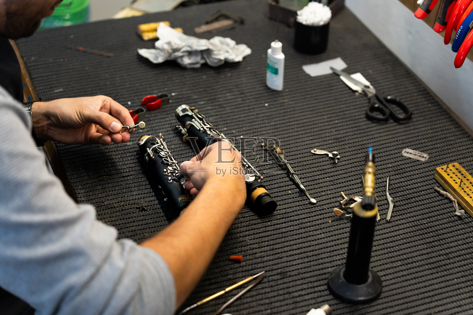 技术人员在工作坊修理木管乐器照片摄影图片