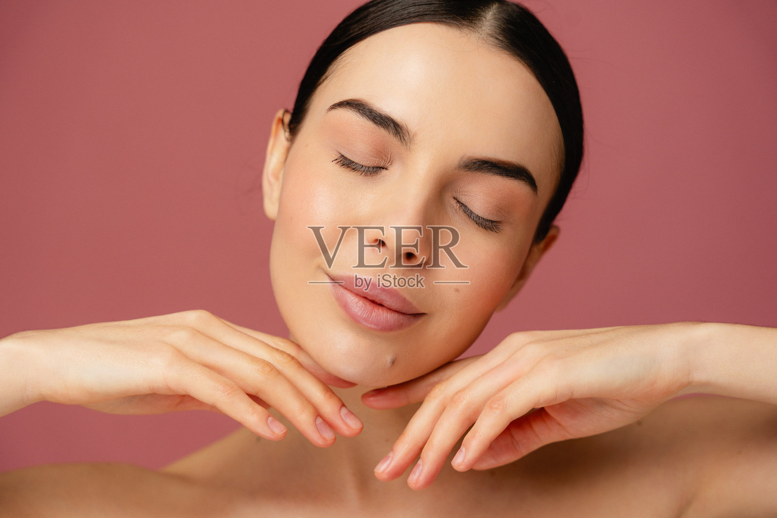 在粉色背景上放松的个体肖像，姿势宁静照片摄影图片