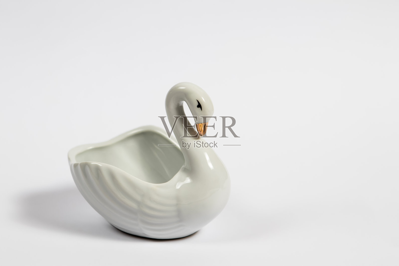 白色天鹅形碗置于白色背景上照片摄影图片