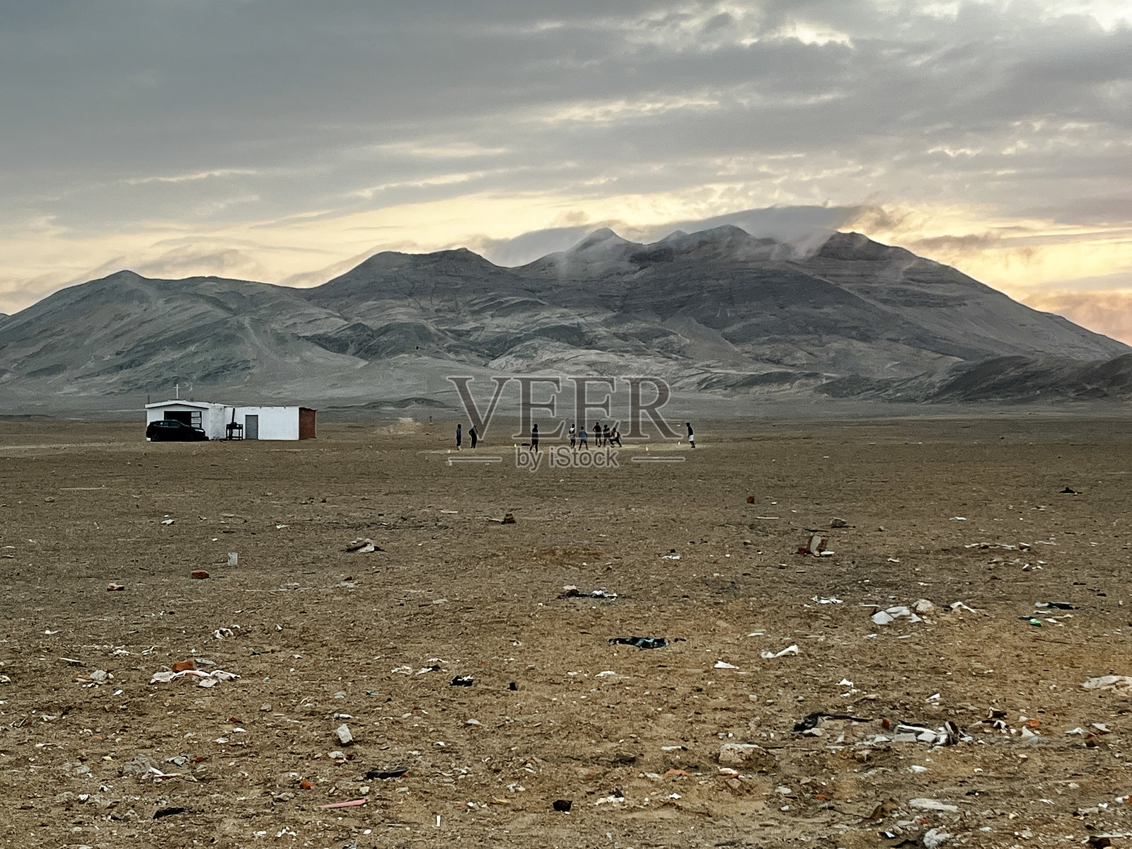 孩子们在沙漠中日落时踢足球照片摄影图片