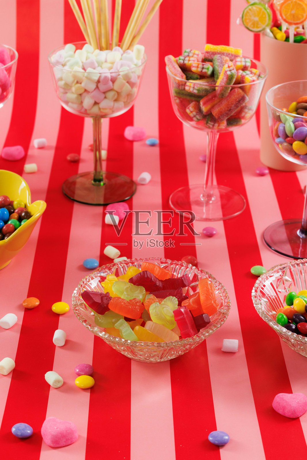 红色和粉色条纹背景上的糖果特写。酸甜糖果。照片摄影图片