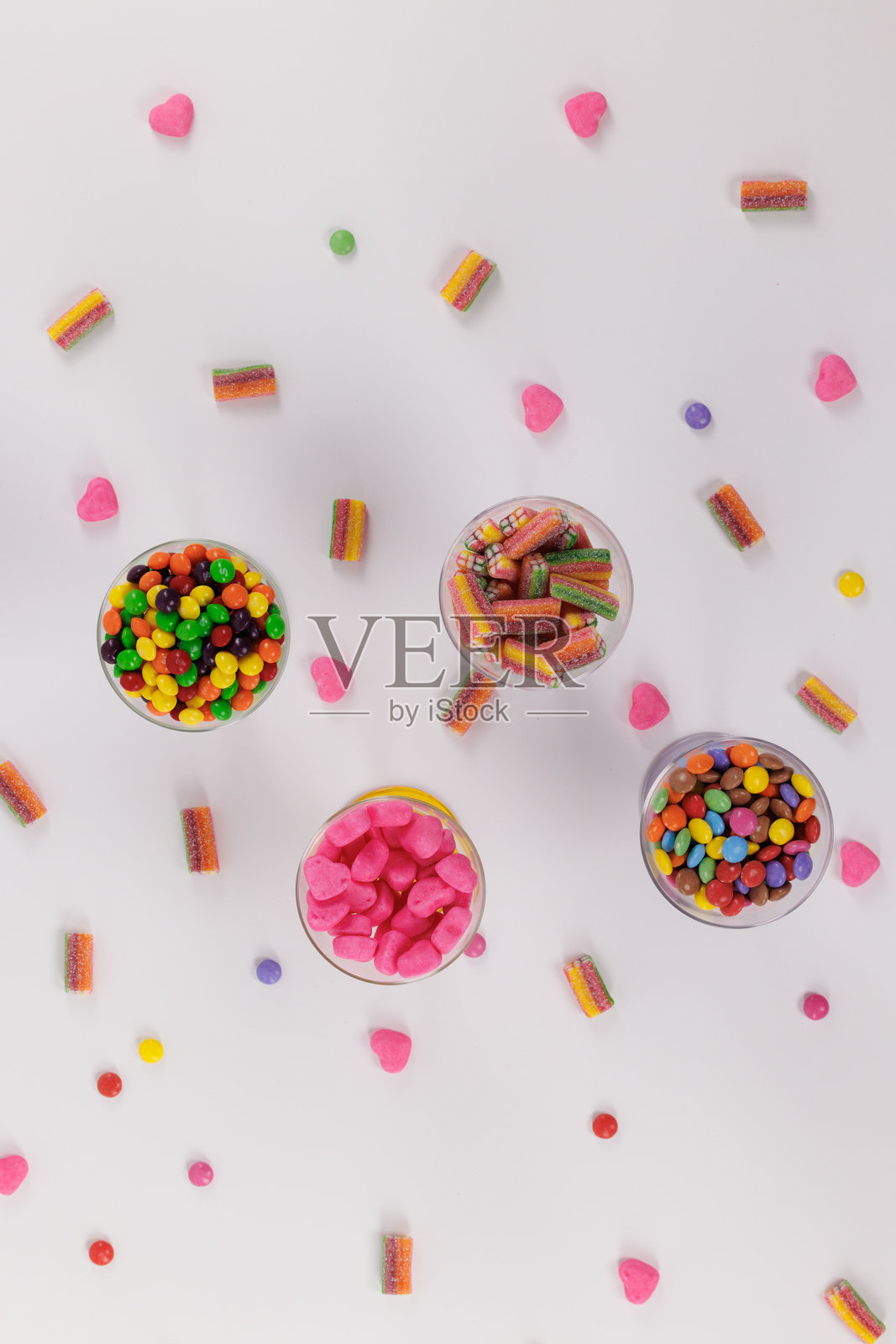 五颜六色的酸甜糖果在白色背景上，俯视拍摄。照片摄影图片