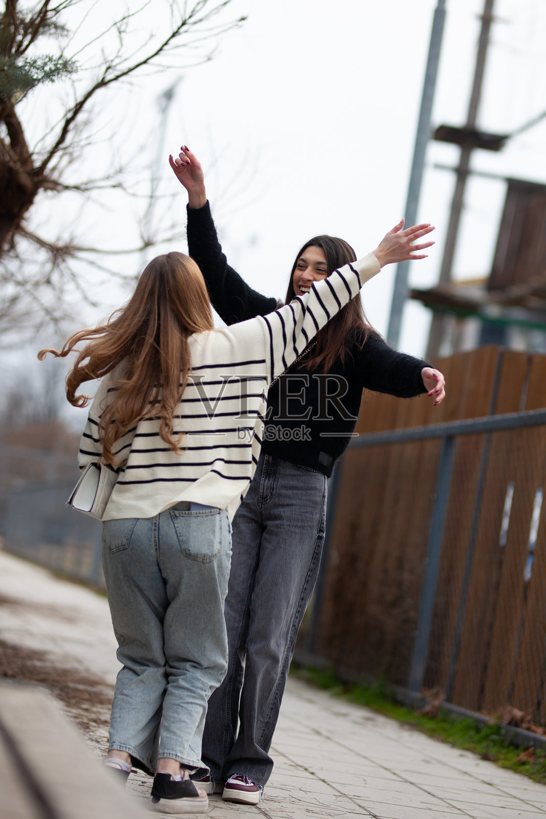 两个朋友在阳光明媚的日子里快乐地重聚并拥抱在一起照片摄影图片