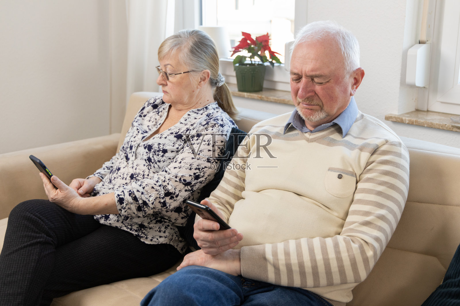 年长夫妻在家沙发上使用手机照片摄影图片
