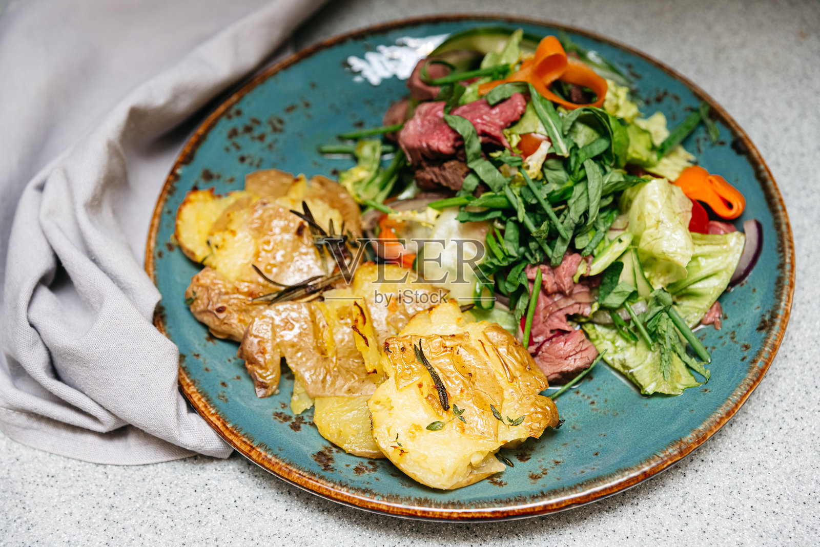 烤土豆和牛肉沙拉盘。照片摄影图片