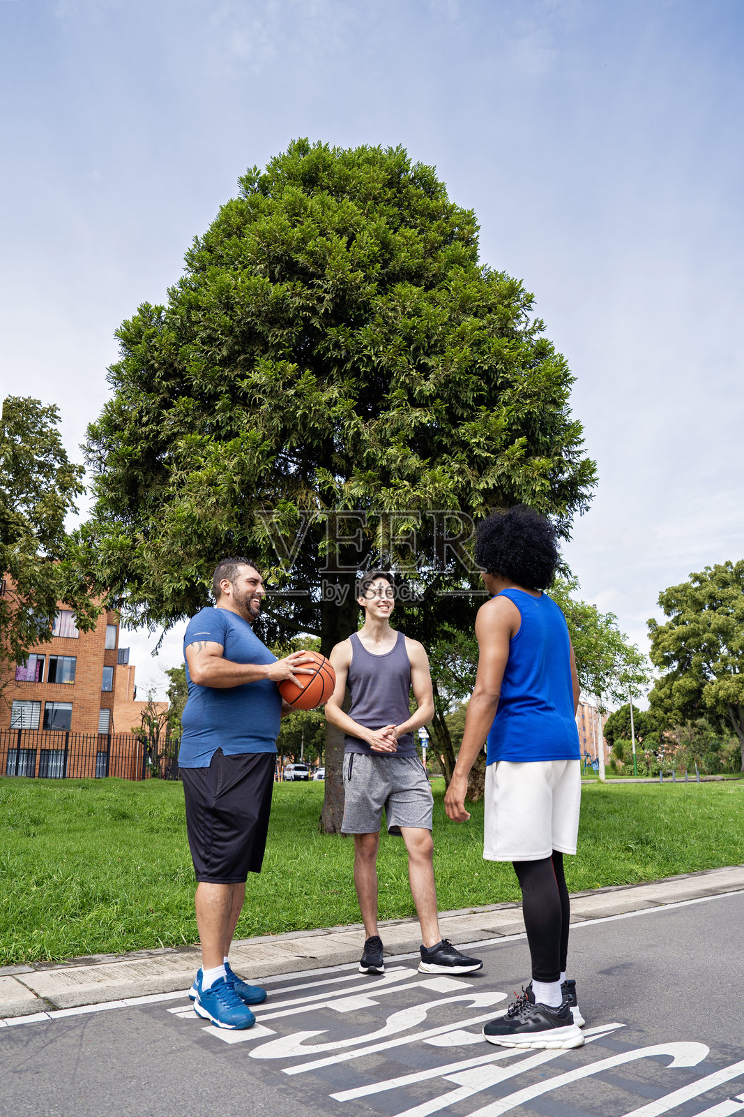 朋友们在公园聊天，准备打篮球。照片摄影图片