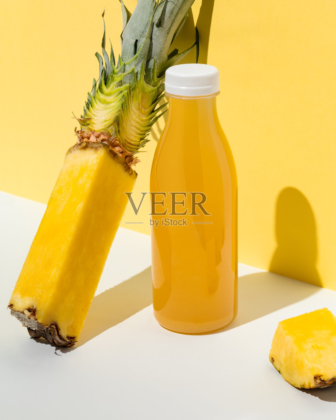 新鲜菠萝汁瓶与切片菠萝在黄色背景上照片摄影图片