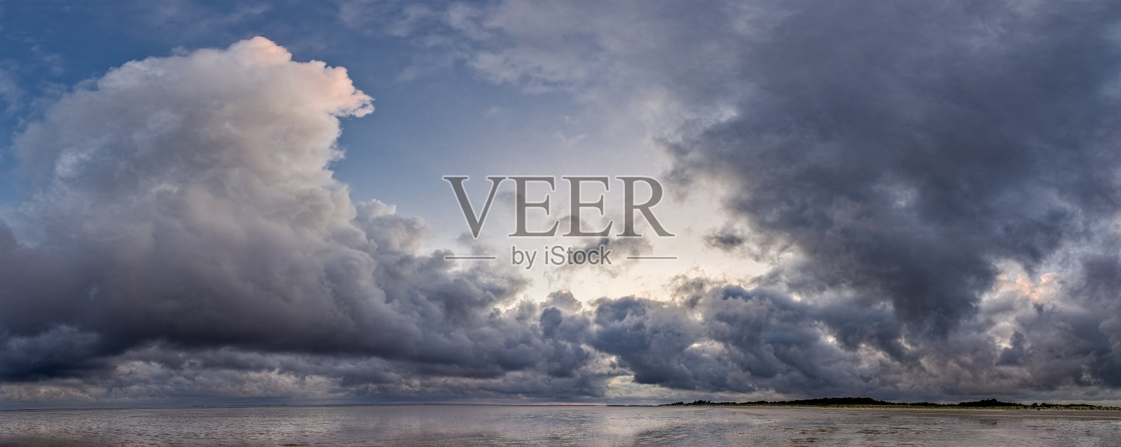 一场飓风低气压伴随着戏剧性的暴风云，正移动在北海岛屿福尔的泥滩上。照片摄影图片