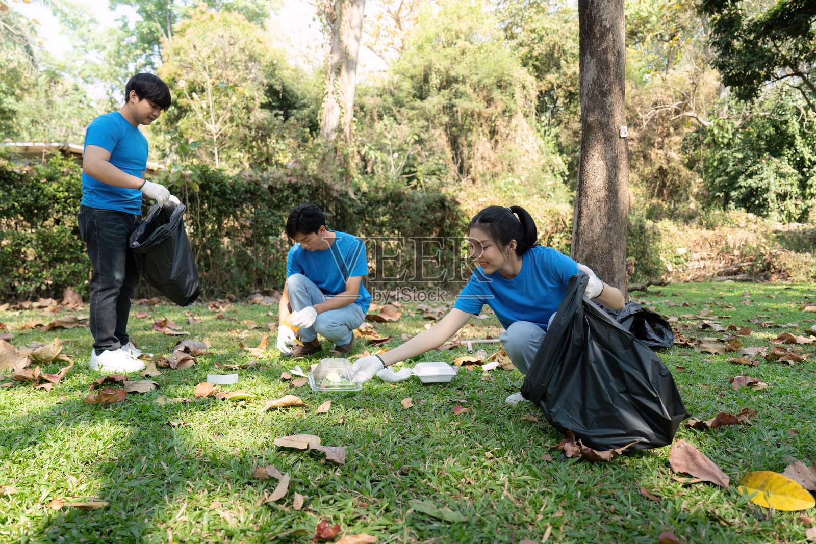 环保意识与团队合作。志愿者们积极收集垃圾，共同努力美化他们的本地公园空间。照片摄影图片