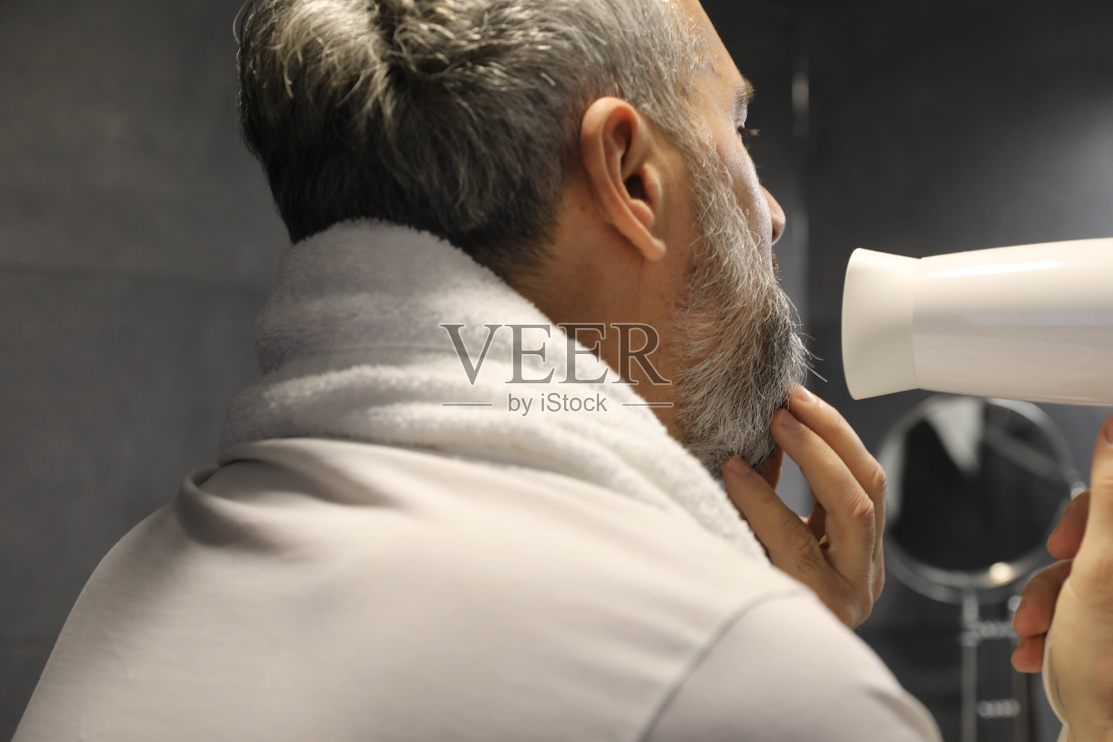 一个中年男人在洗澡后修整他的胡须照片摄影图片