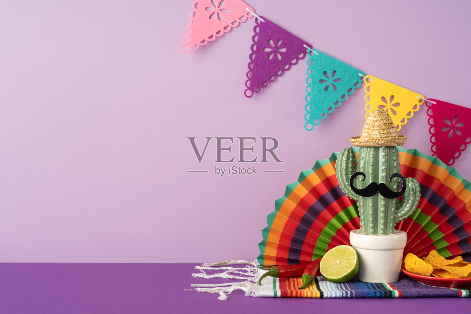 带有草帽、胡须和青柠的仙人掌展示，周围环绕着五月五日的色彩和装饰照片摄影图片