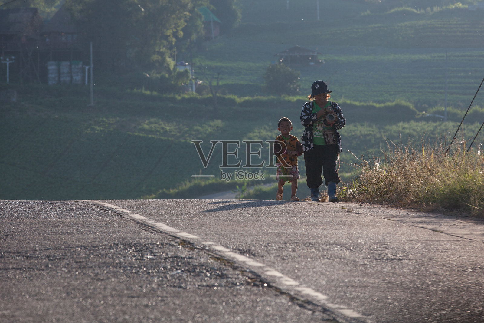 母亲和儿子下班后正走在回家的路上。照片摄影图片