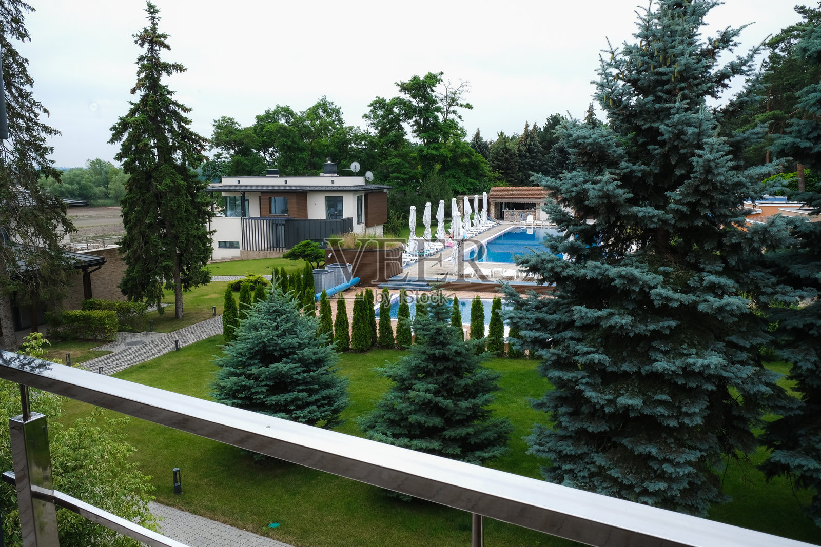 从阳台或露台俯瞰乡村别墅的庭院和游泳池照片摄影图片