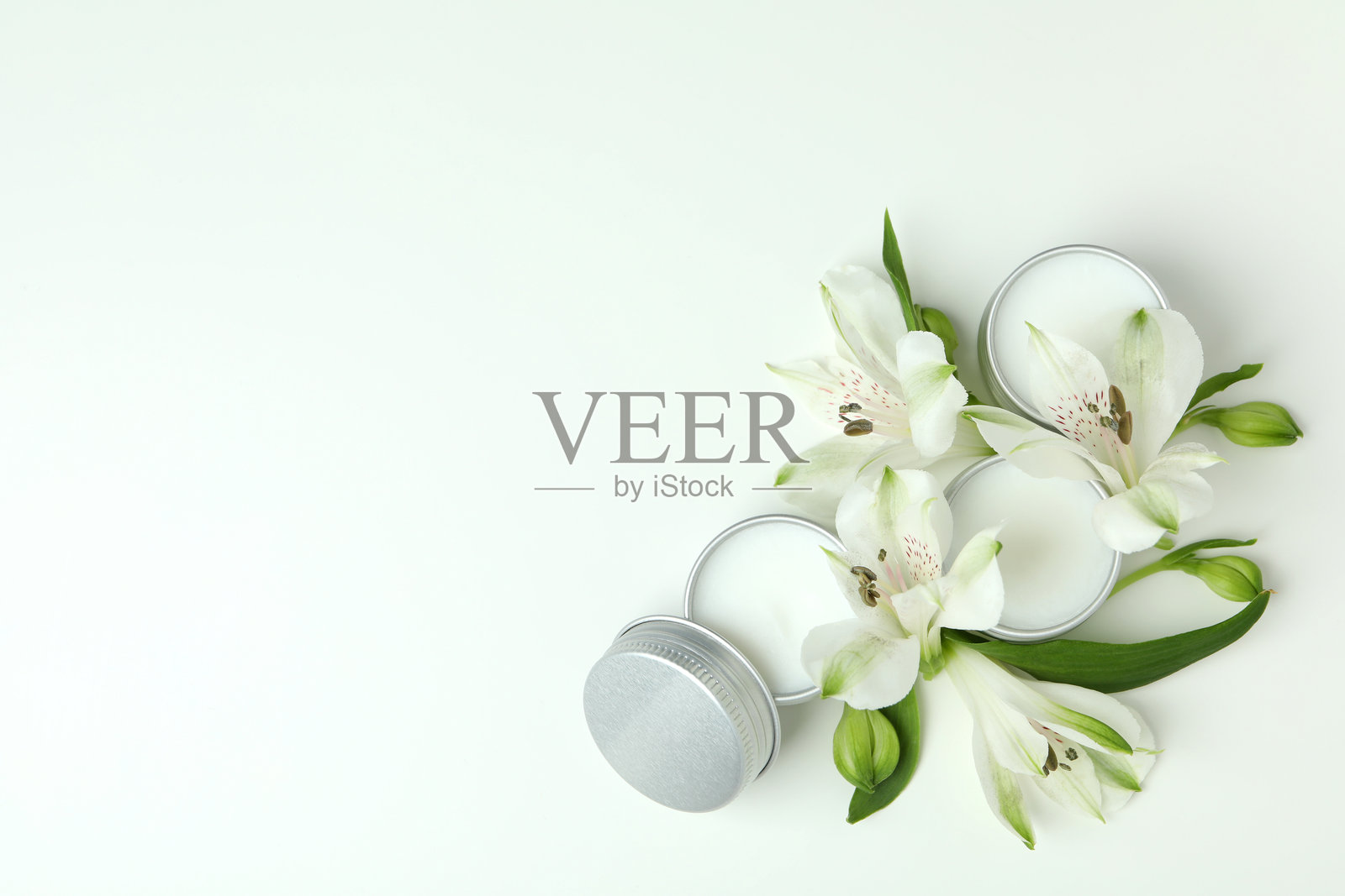 生态润唇膏与白色背景上的花朵照片摄影图片