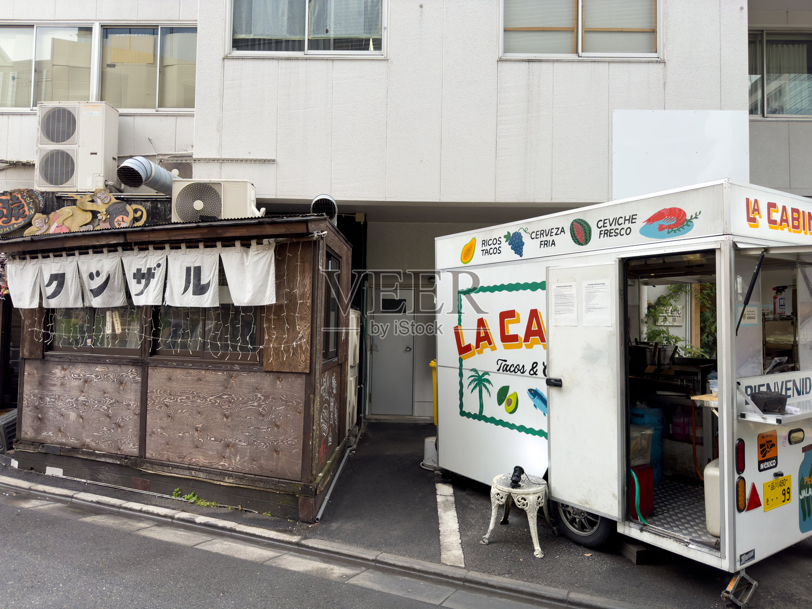 日本东京。街景。传统日本居酒屋旁边是一辆墨西哥餐车。照片摄影图片