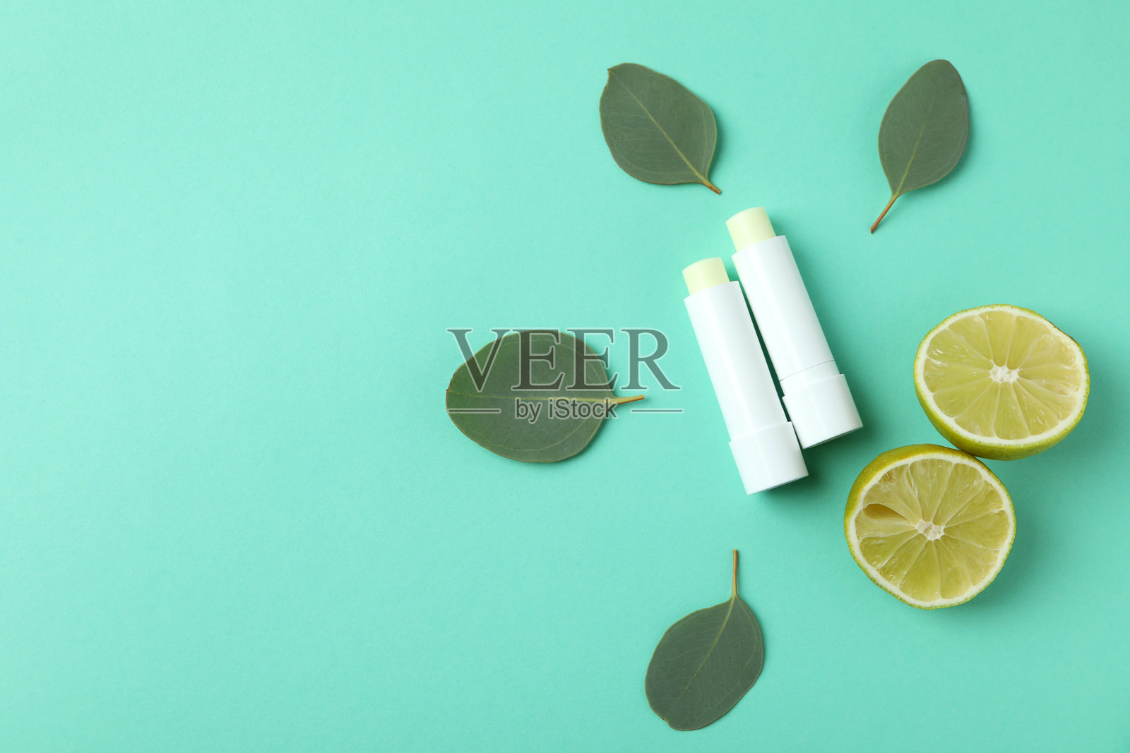 在薄荷色背景上展示的卫生口红的美容概念照片摄影图片