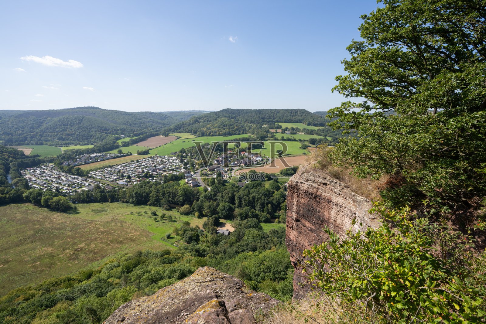 从岩石悬崖俯瞰郁郁葱葱的山谷美景。照片摄影图片