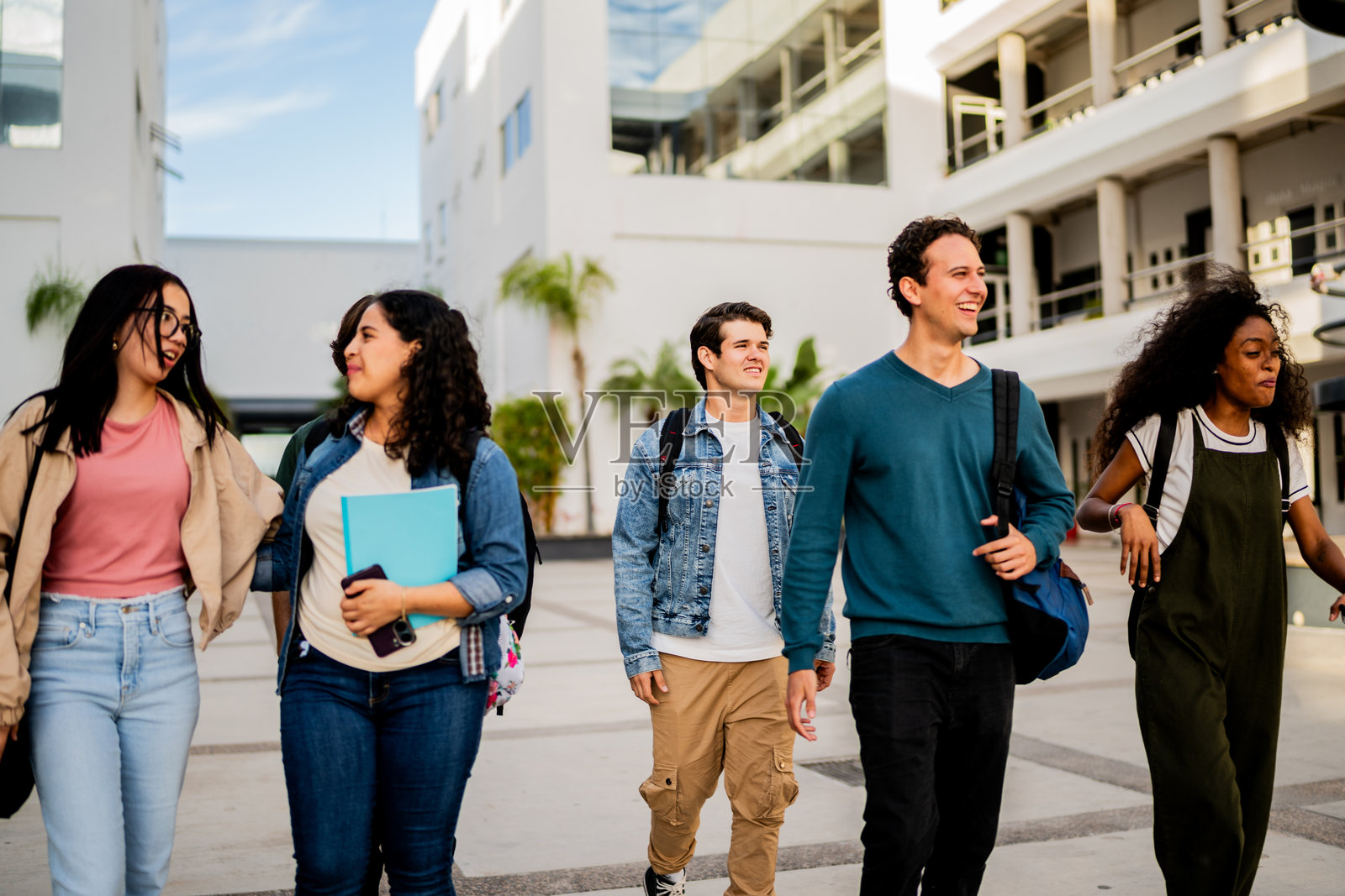 年轻学生朋友在校园里交谈和散步照片摄影图片