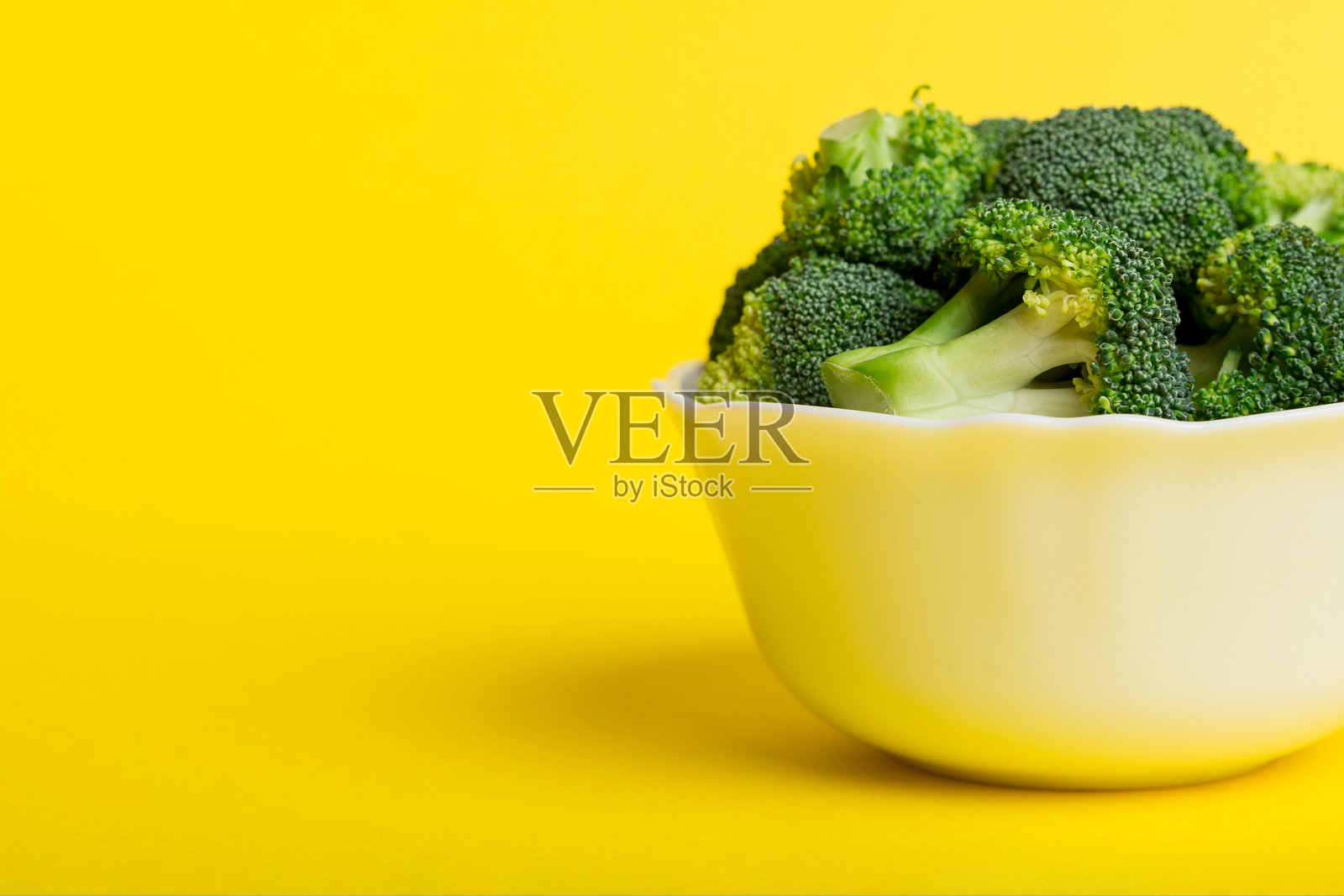 新鲜绿色西兰花在碗中，背景色彩丰富，特写。新鲜蔬菜。照片摄影图片