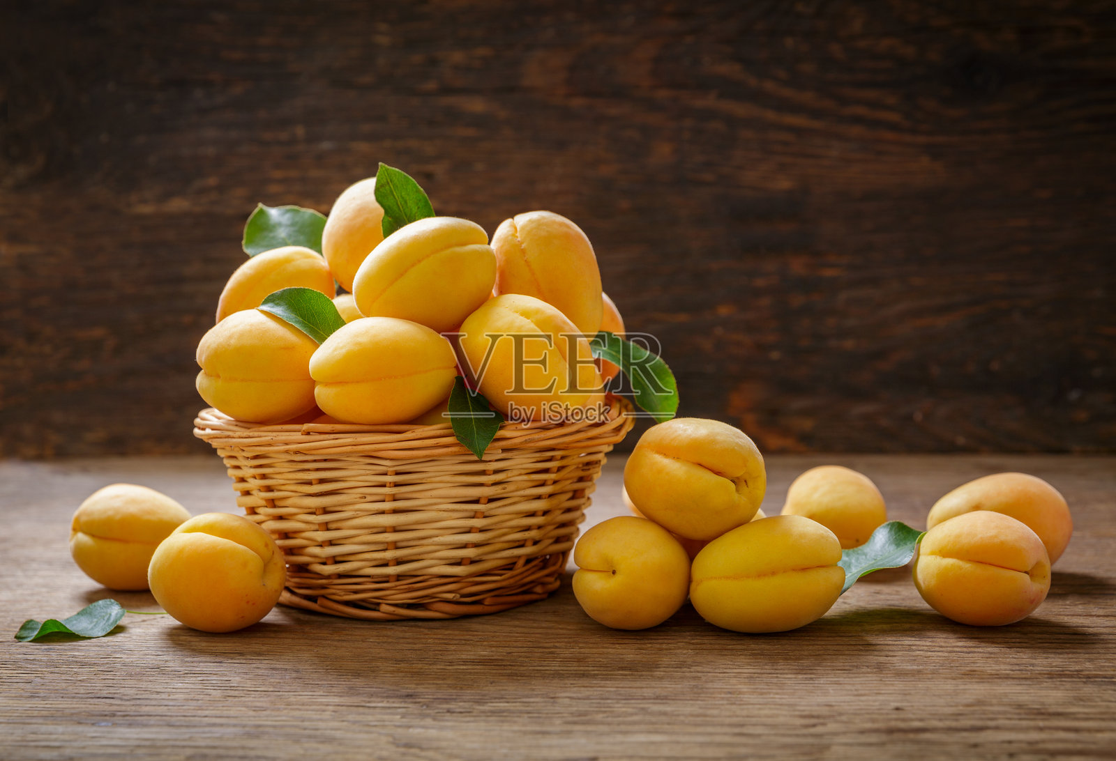 木质背景上的新鲜杏子篮子照片摄影图片