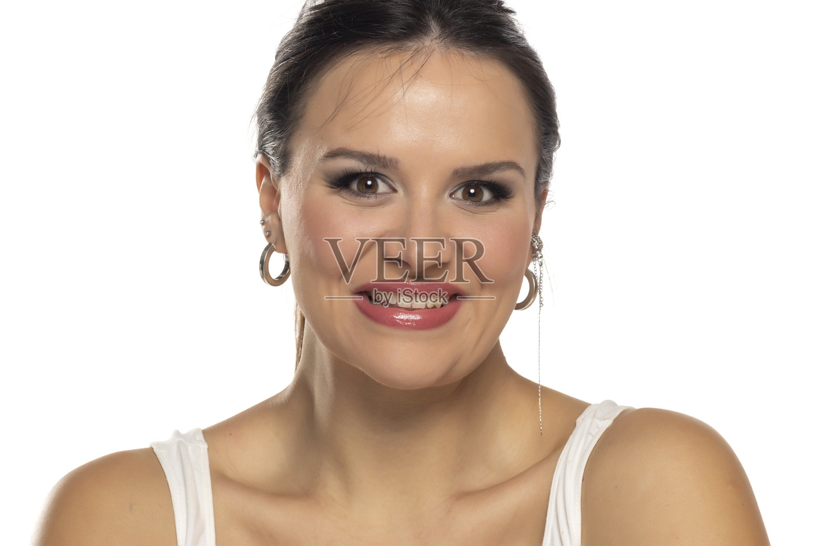 穿着白色上衣的女性灿烂微笑，散发出快乐和自信，背景为白色。照片摄影图片