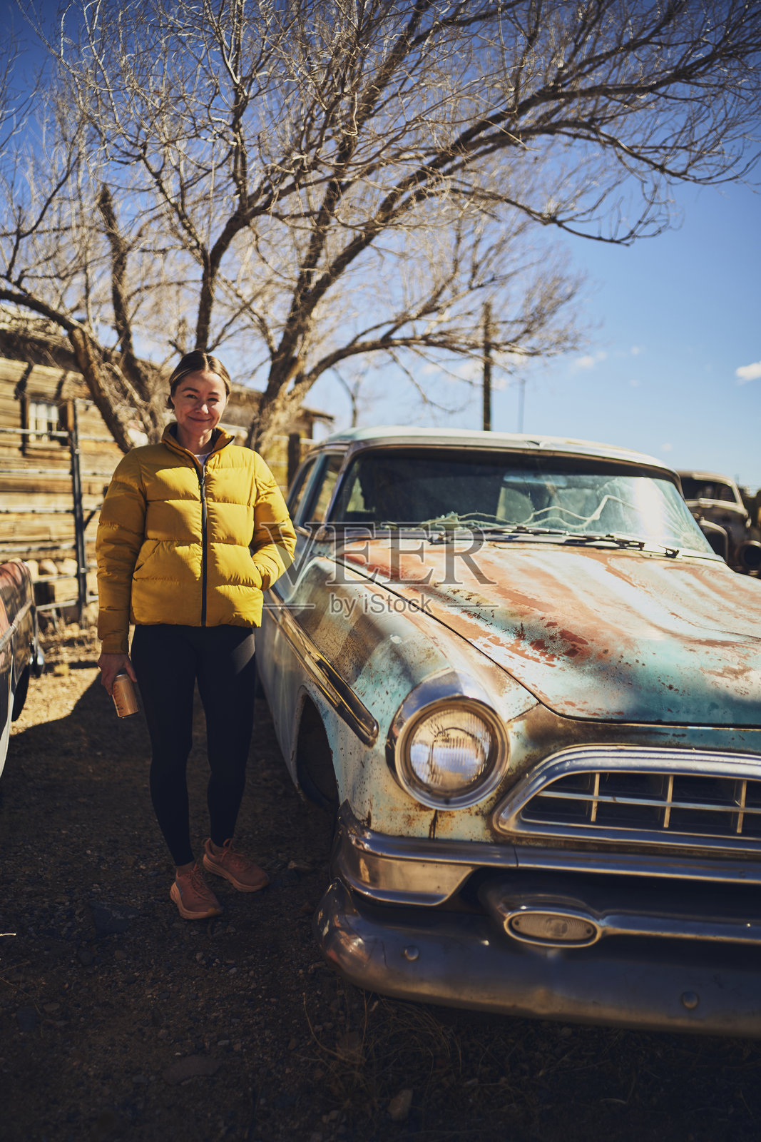 一位女性站在美国西南部的一辆旧车旁边照片摄影图片