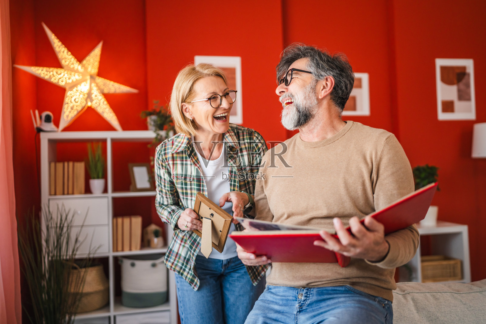 夫妻站在客厅里观看家庭相册照片摄影图片