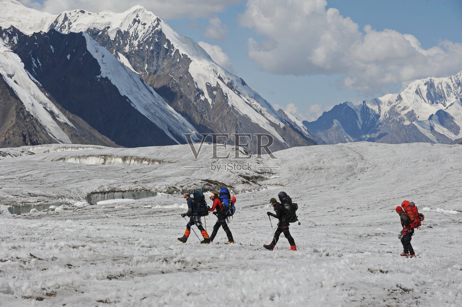 一群人攀登汗腾格里峰。照片摄影图片