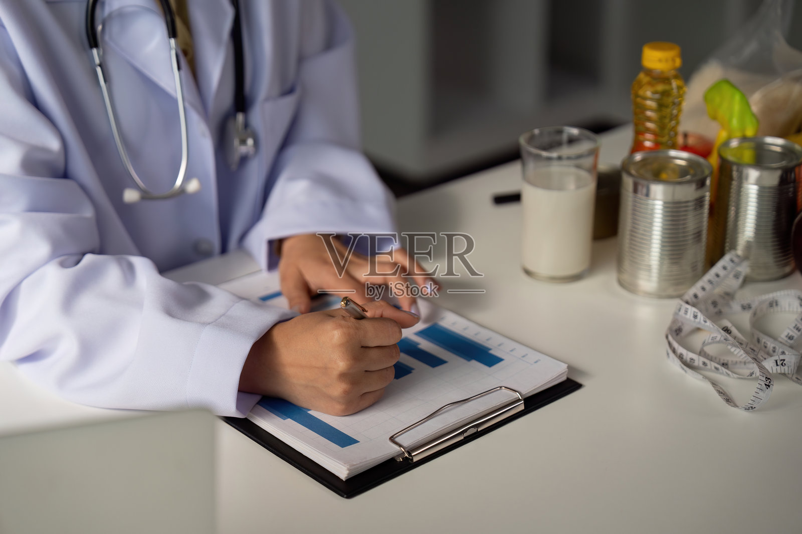 饮食评估与规划。一位医疗专业人员记录饮食选择和健康指标，以及营养项目。照片摄影图片