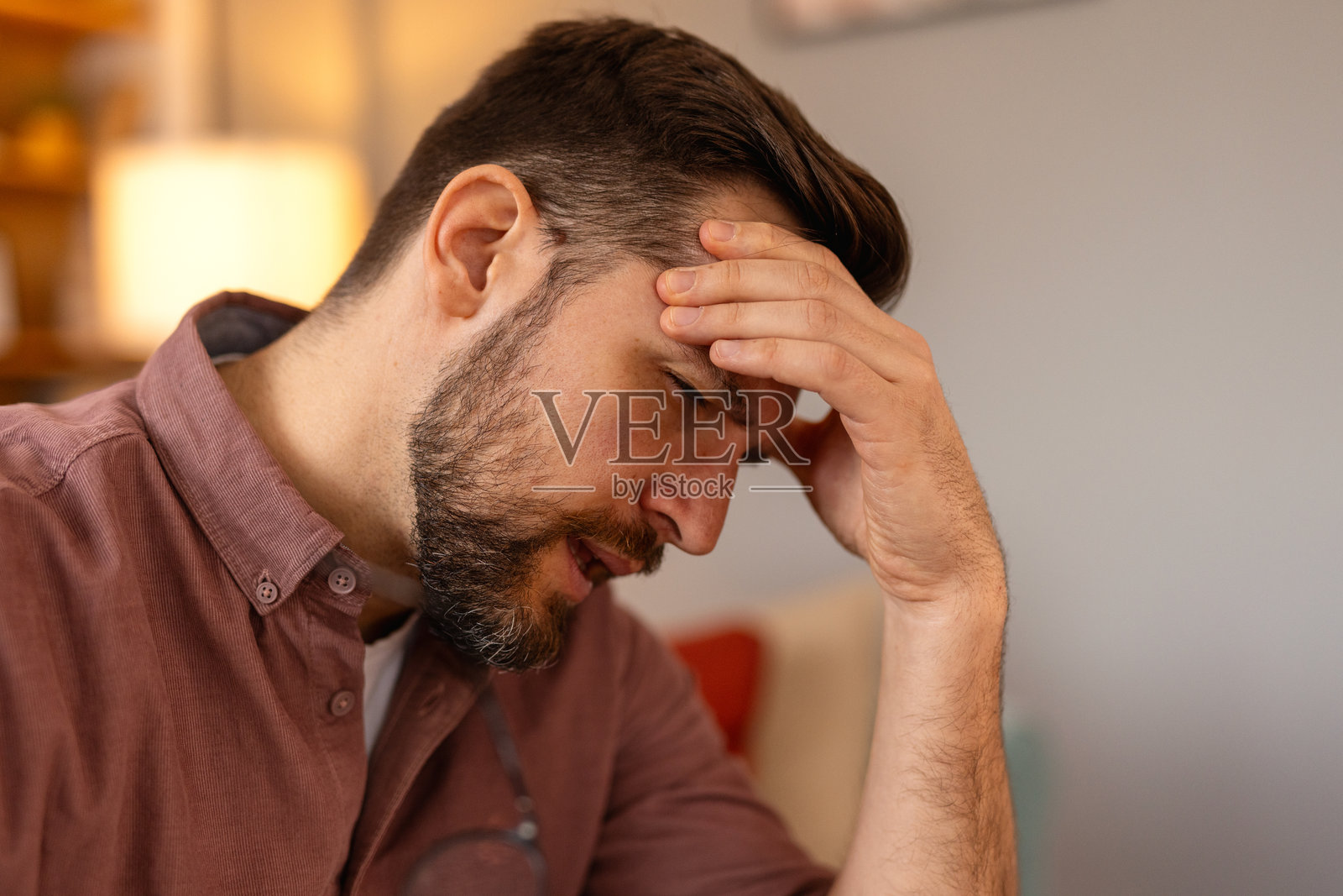 一位面露担忧表情的男性肖像，传达出关切或不确定的感觉。情绪包括压力、焦虑或深思，心理健康、压力和人类情感。照片摄影图片