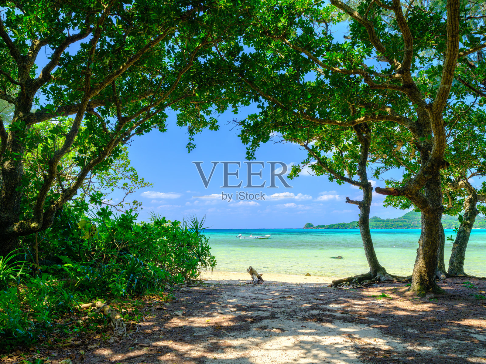 夏季时分，位于日本冲绳石垣岛的须久治海滩，蓝色海洋或海洋上漂浮着一只美丽的船，白色沙滩旁无人，风景或旅行，高分辨率超过50MP照片摄影图片