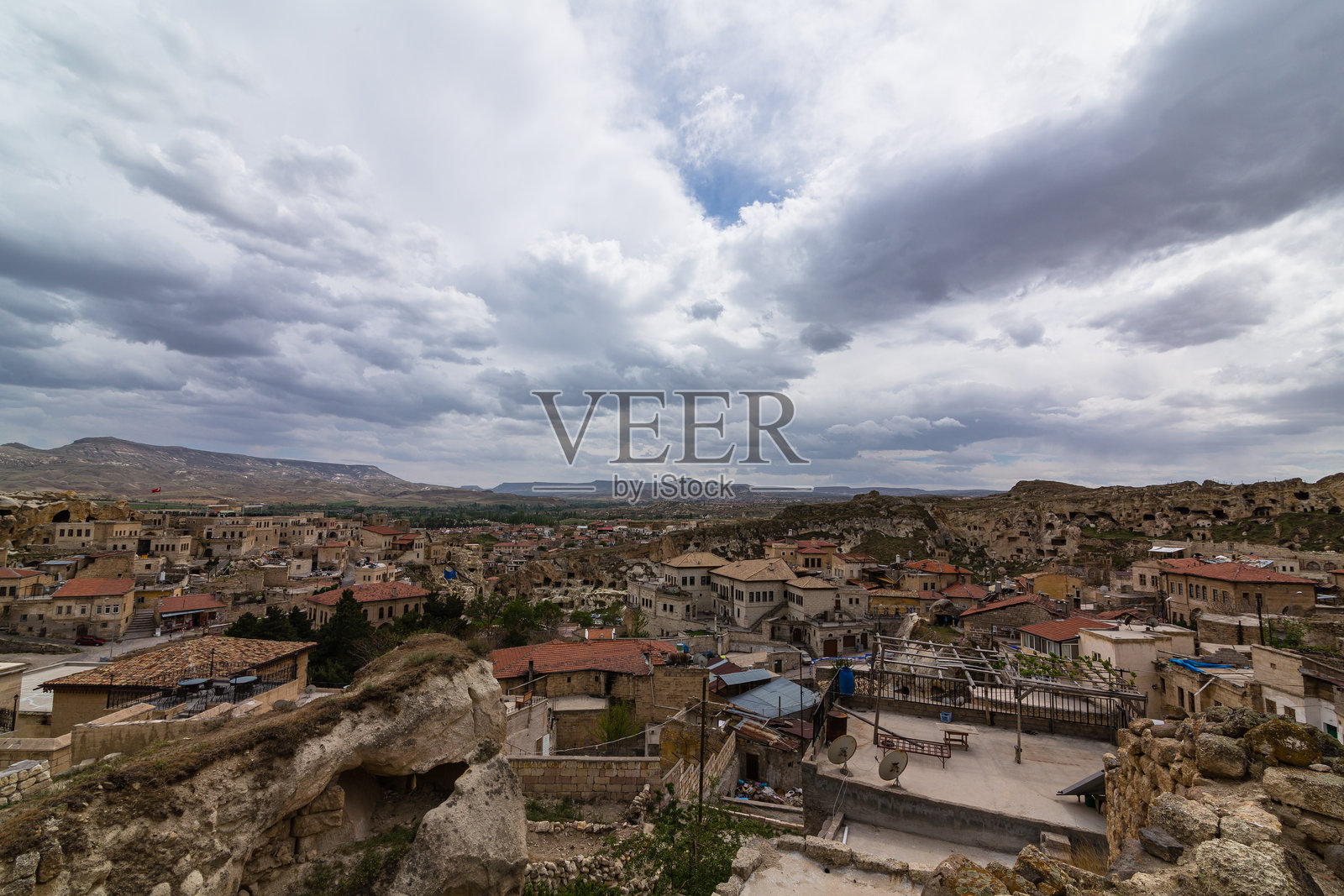 从土耳其卡帕多奇亚的旅游基地乌尔居普的山丘上看到的城市景观照片摄影图片