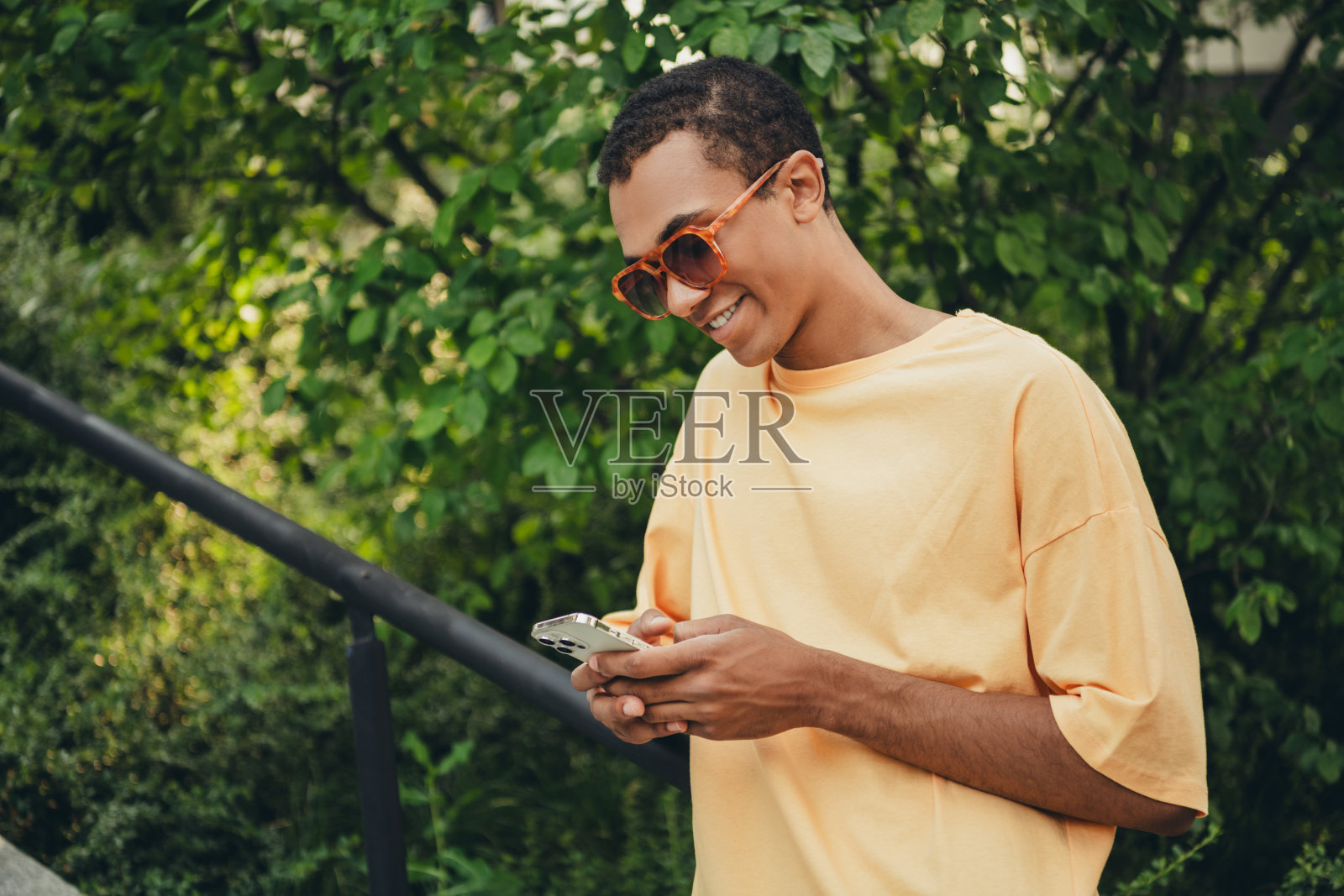 年轻的非裔美国男性穿着休闲服装，享受阳光明媚的户外时光照片摄影图片