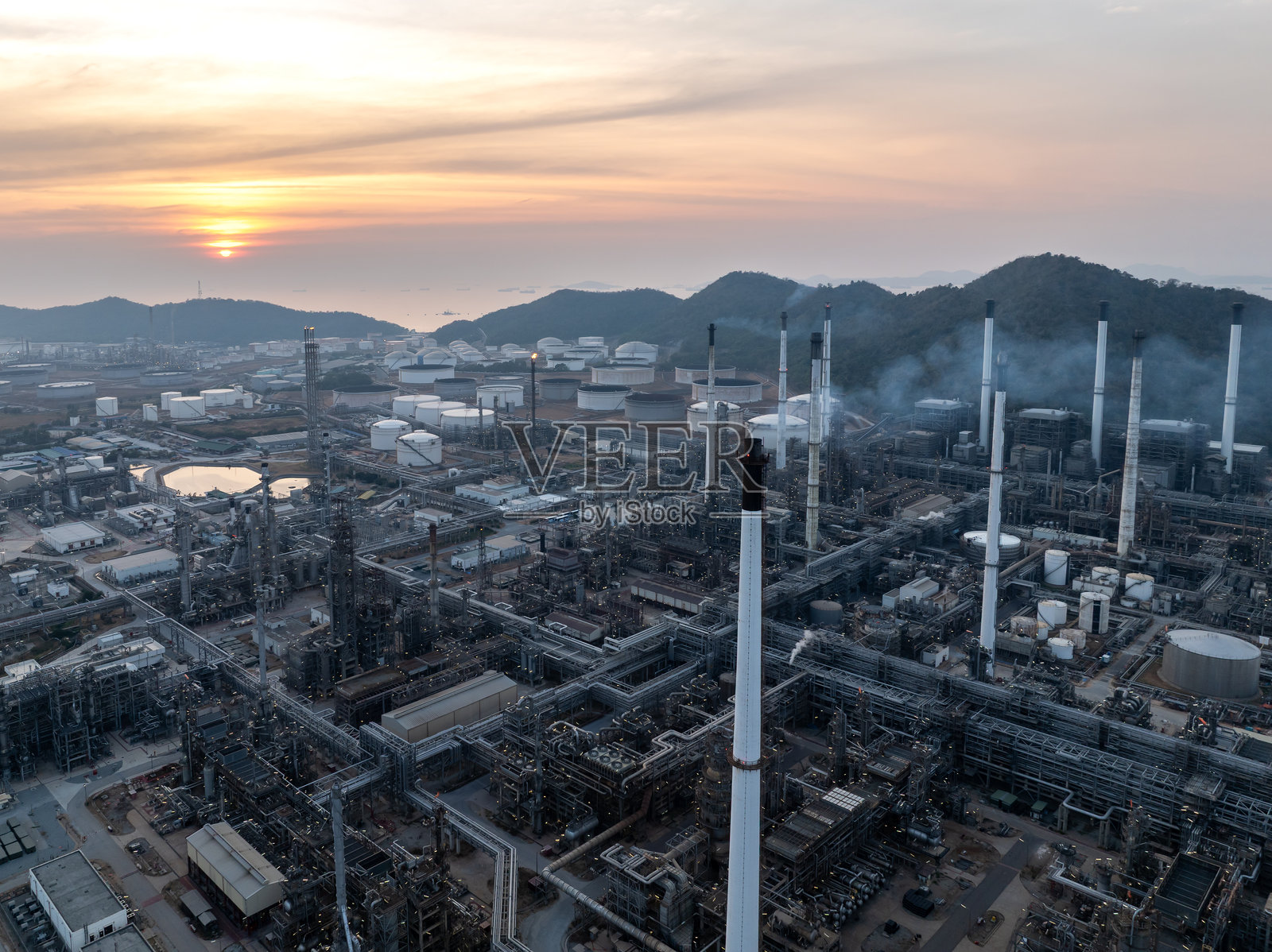 石油和天然气炼油厂，工业和金融业务相关的能源，废能和空气污染，夕阳背景。照片摄影图片