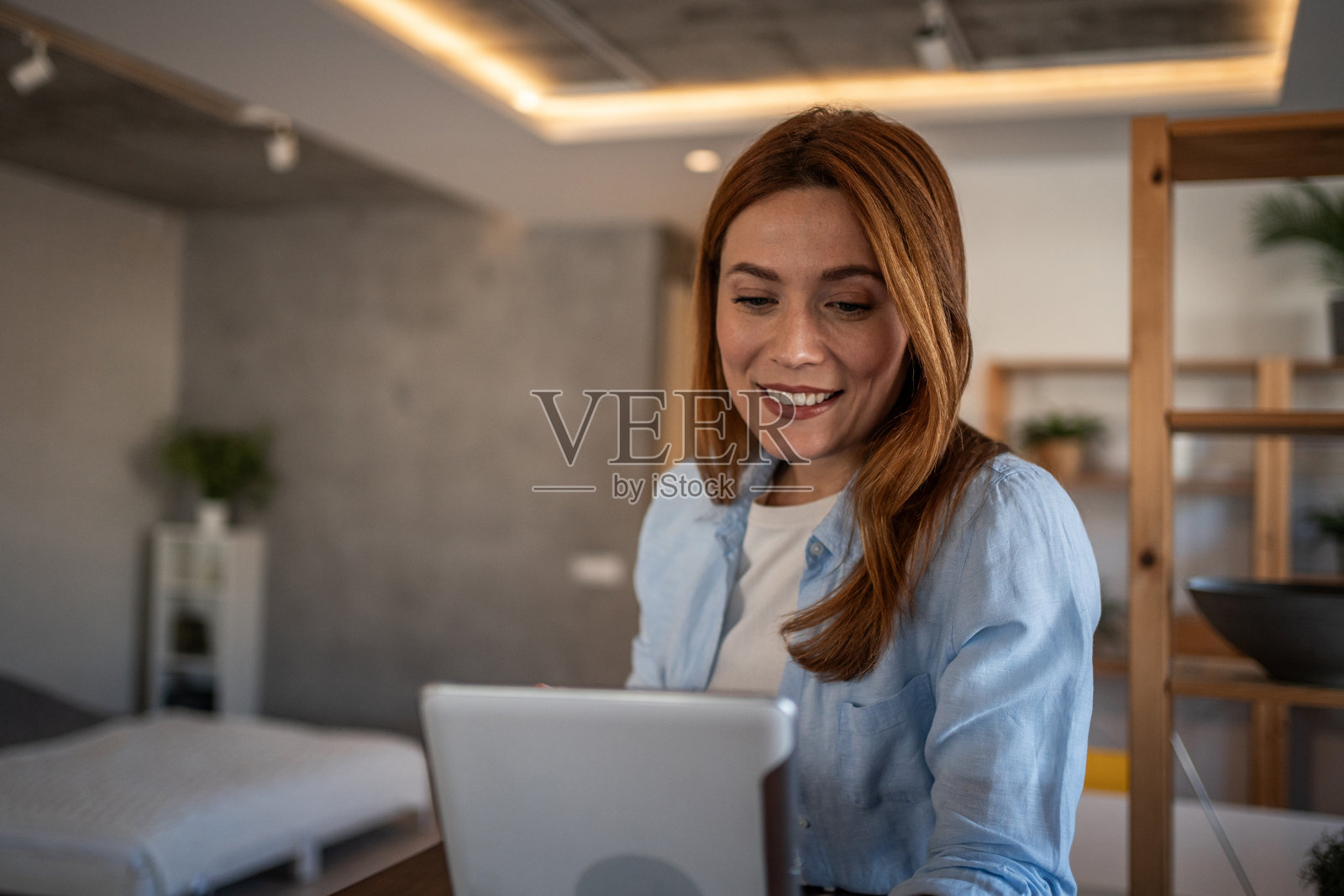 微笑的女性在家中使用平板电脑工作照片摄影图片