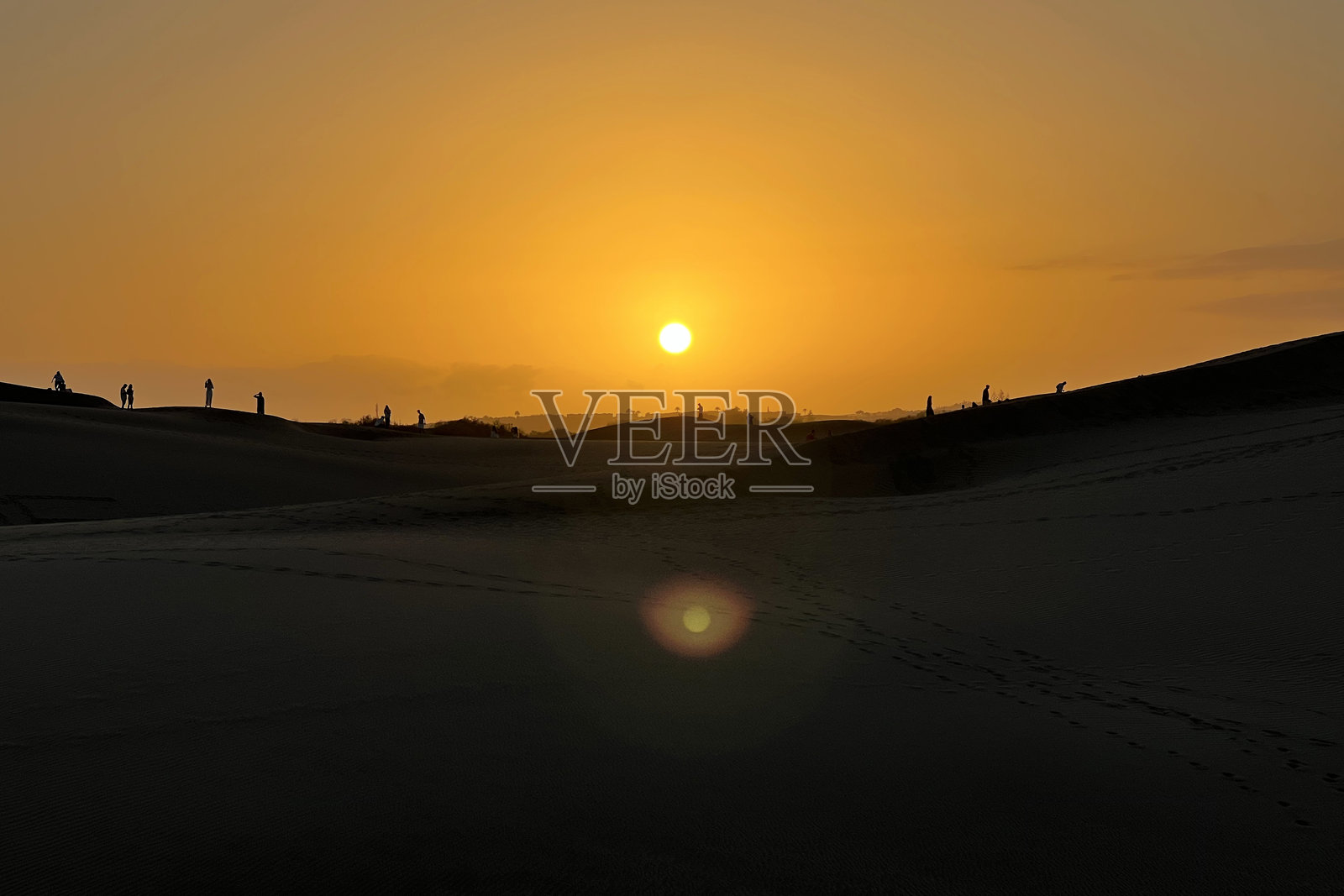 人们在大加那利岛的马斯帕洛马斯沙丘观看五彩斑斓的日落照片摄影图片