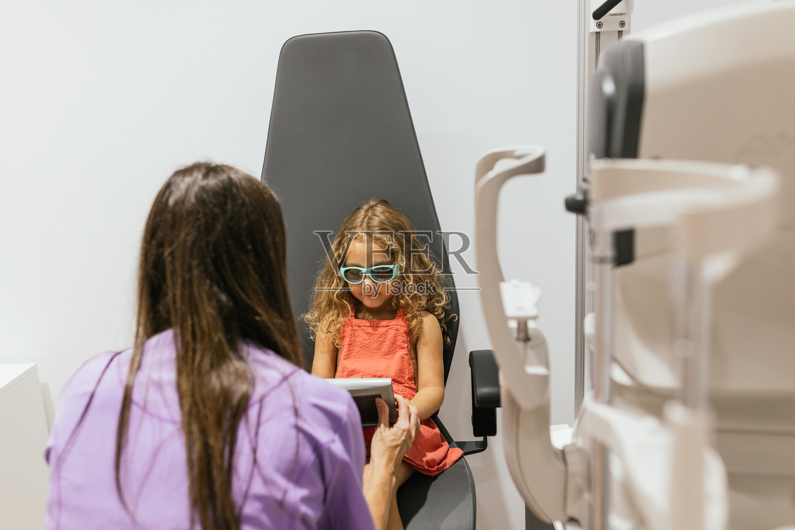 儿科验光师在诊所为小女孩进行眼部检查照片摄影图片