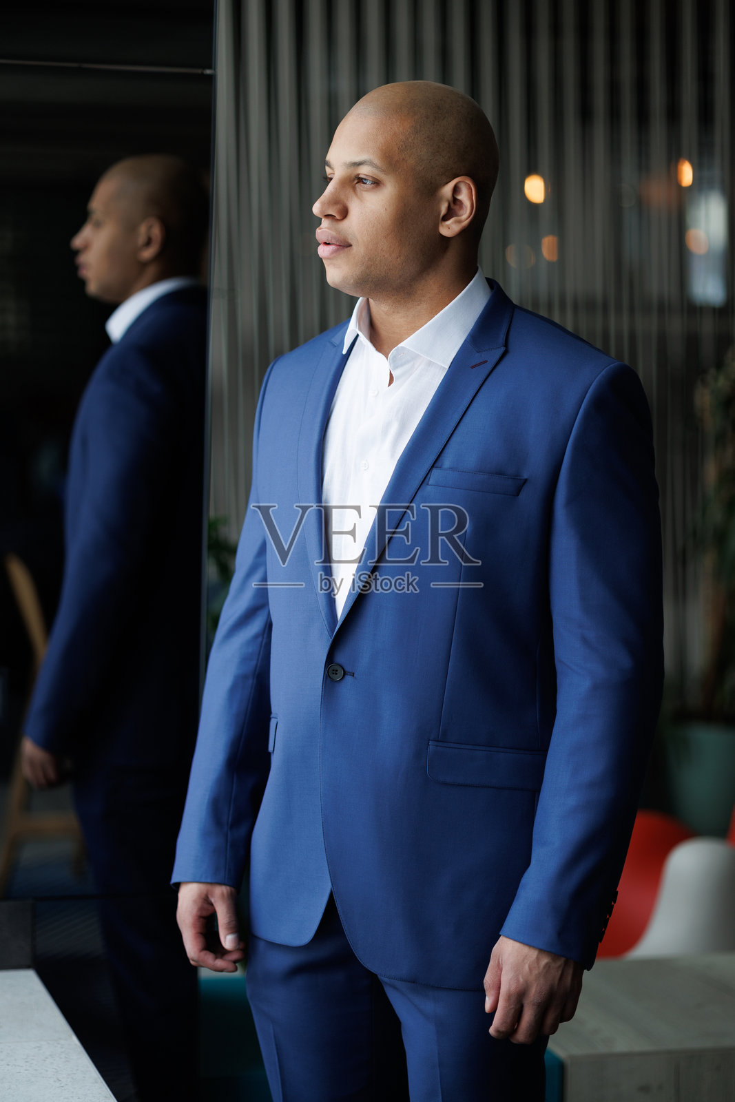 身穿蓝色西装的非裔美国商人在酒店中侧目而视照片摄影图片