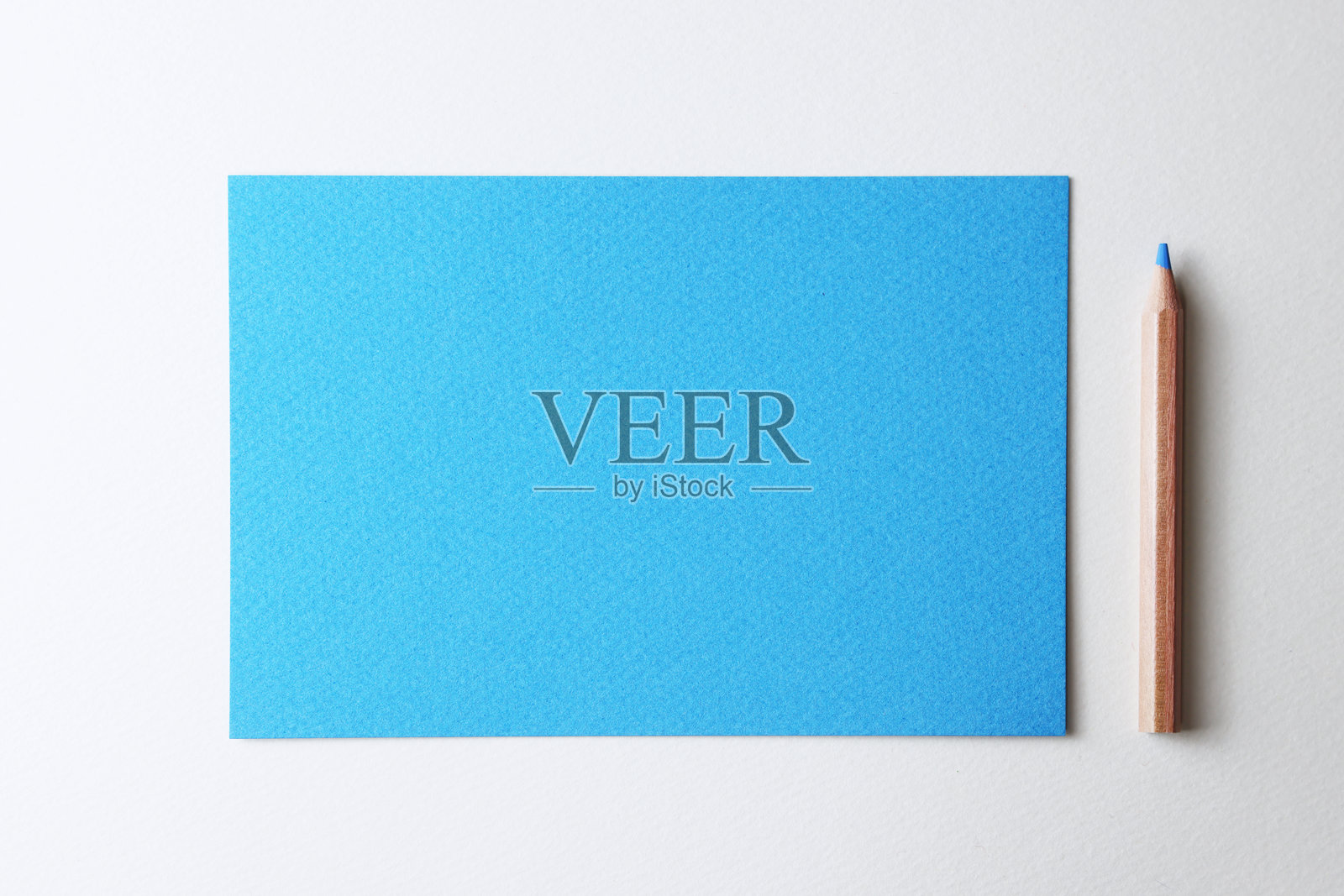 白色背景上的蓝色纸张和铅笔。照片摄影图片