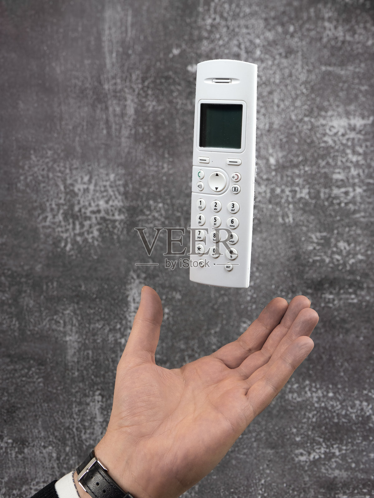 手在空中放下一个白色电话听筒照片摄影图片