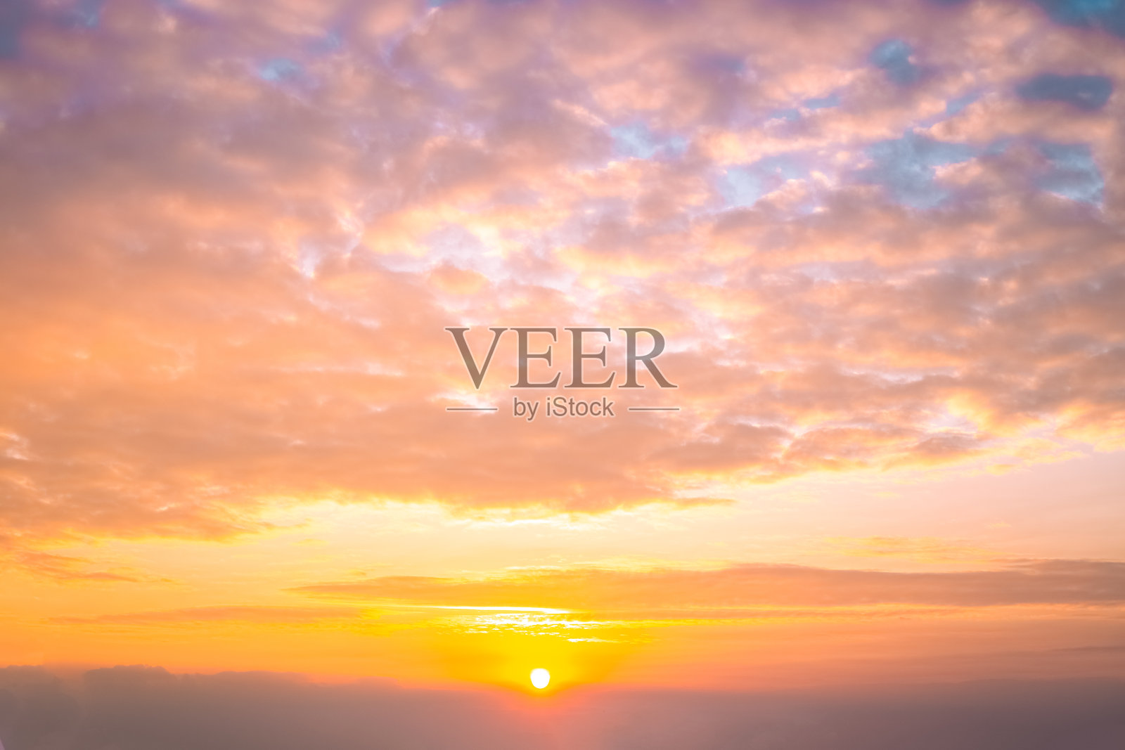 美丽的天空在日落时分，云朵成团，柔和的粉橙色。天上的风景。照片摄影图片