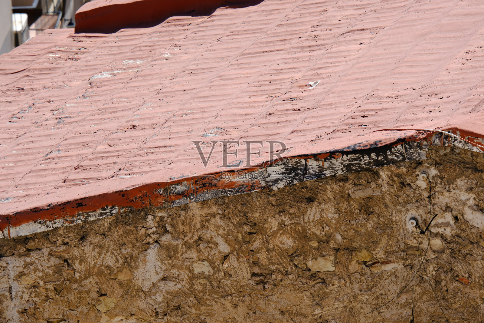 风化的红瓦屋顶，位于质朴的石建筑上，展现出纹理和岁月的痕迹照片摄影图片