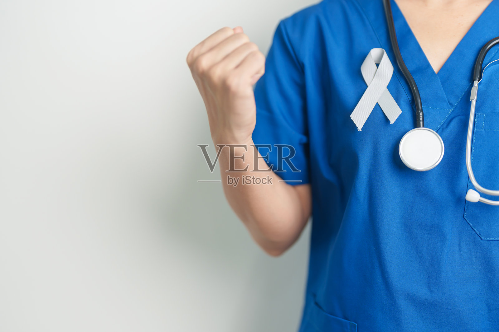 脑癌意识月，医生手持灰色丝带以支持生命。医疗保健与世界癌症日概念。照片摄影图片