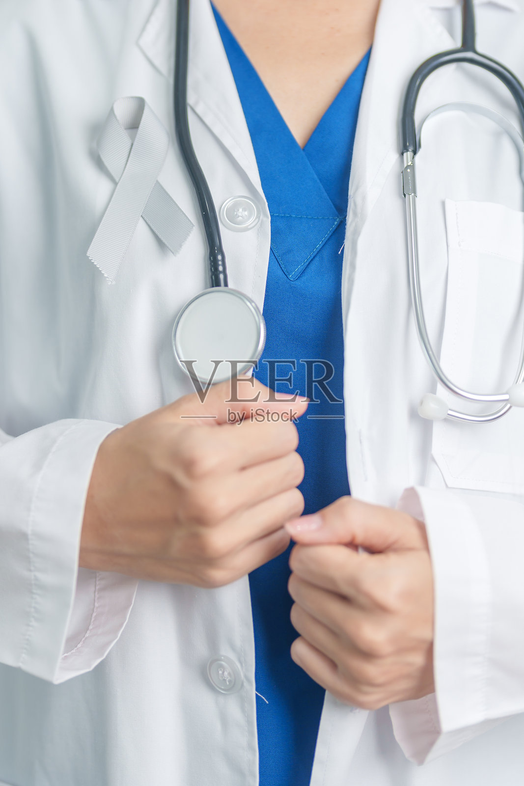 脑癌意识月，医生手持灰色丝带以支持生命。医疗保健与世界癌症日概念。照片摄影图片