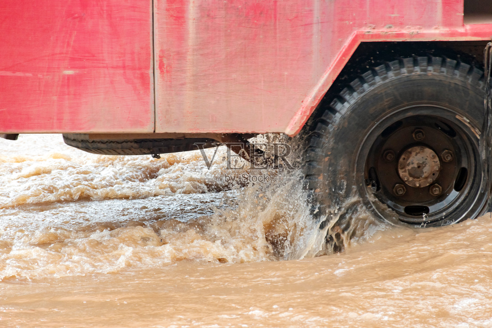 汽车在因大雨造成的洪水路段行驶。照片摄影图片
