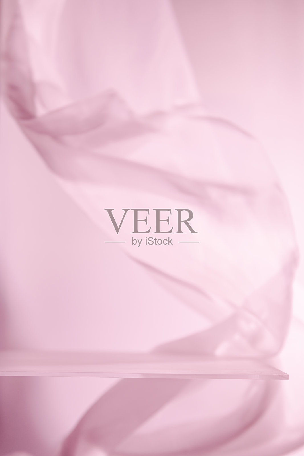 空玻璃架子配有流动的粉色布景，营造出柔和优雅的氛围，理想用于展示产品或创造极简主义美感。照片摄影图片